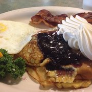 Blueberry Swedish pancake with side of eggs and bacon