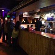a group of people standing at a bar