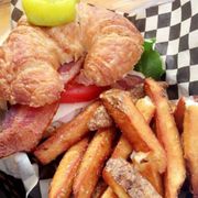 a croissant sandwich and french fries