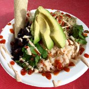 Chili verde pork rice bowl with lime rice, cumin black beans, cilantro, avocado, corn tortilla, Santa Fe crema and house made hot sauce
