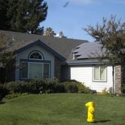 a yellow fire hydrant in front of a house