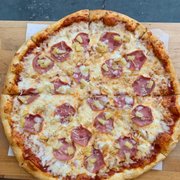 a pizza with ham and pineapple toppings