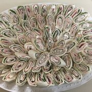 a platter of rolled up sandwiches