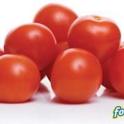 a pile of tomatoes on a white surface