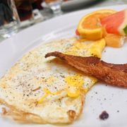 an omelet, bacon, and fruit