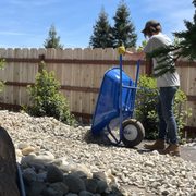 a woman pushing a wheelbarrow