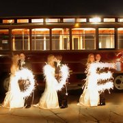 a bride and groom with sparklers in front of a trolley