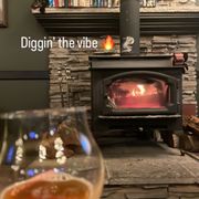 a glass of wine in front of a fireplace