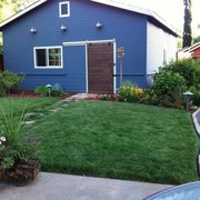 a backyard with a blue house