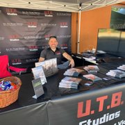 Owner Ev Durán mans the booth at Johnny Appleseed Days, an event U.T.B. Studios has sponsored for two consecutive years