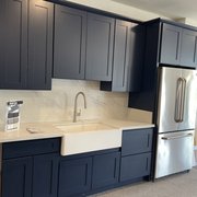 new blue shaker cabinetry, with a Karran apron front quartz sink.