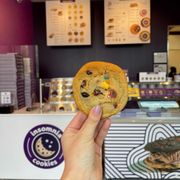 a hand holding a chocolate chip cookie