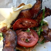 Inside the Brie LT Bacon, sliced brie, fresh tomato & fresh spinach with house made fresh basil mayo on a grilled torta roll.