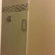 Master shower with vanilla ice walls with tile inlay that matches the vanity.