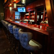 a row of bar stools in front of a television