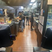 a group of people standing in a kitchen