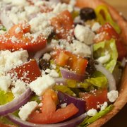 Greek Salad: Crisp romaine lettuce, fresh tomatoes, red onions, feta cheese, cucumbers, Kalamata olives, pepperoncinis