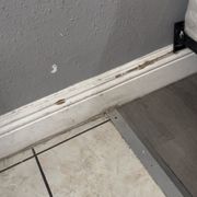 Tile baseboard and floors are filthy