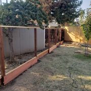 a fenced in yard with a tree in the background