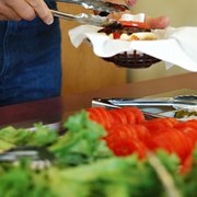 a person holding a spoon over a plate of food