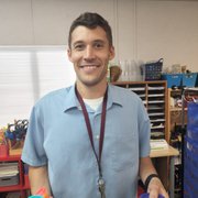 a man in a blue shirt holding a cup