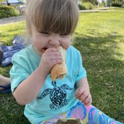 a little girl eating a hot dog