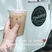 a hand holding a cup of iced coffee