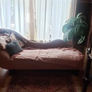 A fainting couch is conveniently located at the top of the stairs