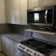 Alpina White Silestone Counters with full height backsplash, and New Grand J&K Cabinets