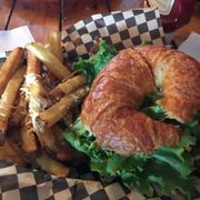 a croissant sandwich and french fries