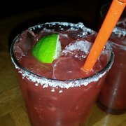 a close up of two margaritas on a table