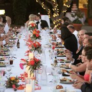 a group of people sitting at a long dinner table