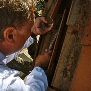 Tracy removes an extensive bee hive from under a second-story tile roof in Butte Valley.  The hive was a class project gone awry.