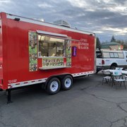 a red food truck parked in a parking lot