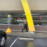 a man walking in front of a mcdonald's