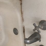 a dirty bathtub and faucet
