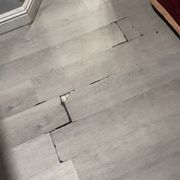 Wooden floors are cracked and sticking up. Tripping hazard. This will definitely cut your feet open if you walk on it.