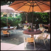 tables and chairs with umbrellas