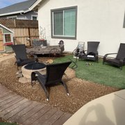 a patio with chairs and a fire pit