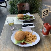 Patio, burgers, fries and a salad.