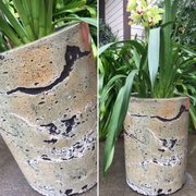 Concrete flowerpot with leather and olive coloring.