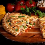 a pizza cut in half on a cutting board