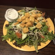 a plate of salad with tofu croutons