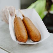 two hot dogs in a paper basket