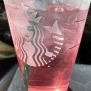 a pink drink in a plastic cup