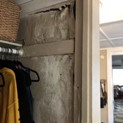 a view of a closet with clothes on hangers