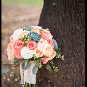 Tightly packed bridal bouquet with garden roses and succulents.