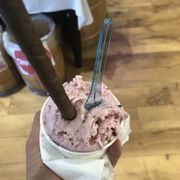 a hand holding a cup of ice cream
