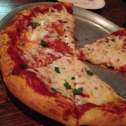A tasty cheese pizza with some flat leaf parsley on top.