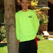 a young man standing in front of a tree